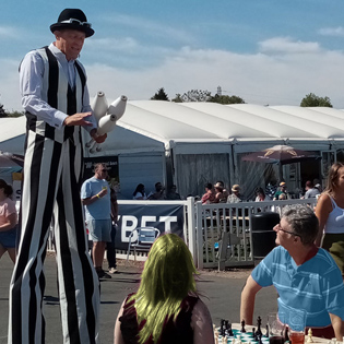 Stiltwalker at Beer festival chats to chess players